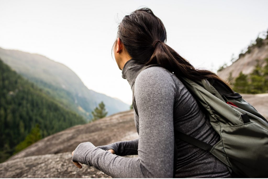 A woman pausing to take in the view on a mountain trail