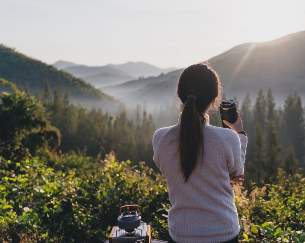 A woman pausing to take in a peaceful mountain view